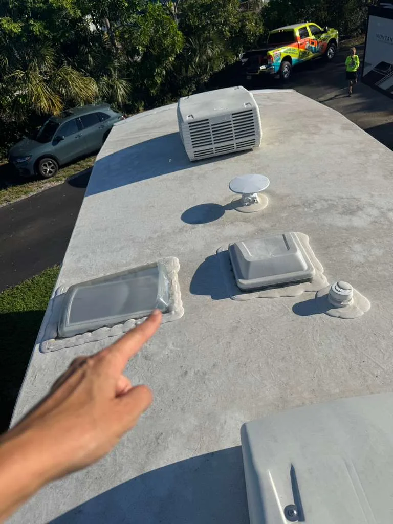Roadwise RV technician repairing a rubber roof leak on an RV in Florida