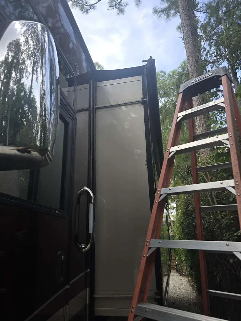 Roadwise RV technician working on a stuck slide-out at a Florida campsite